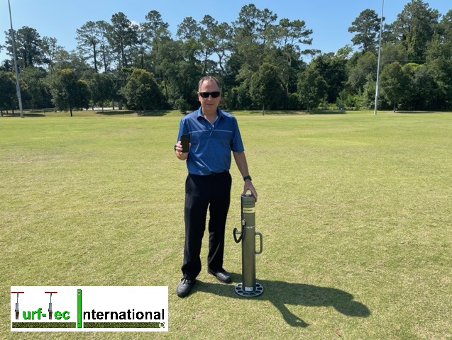 Turf-Tec International Agent John Mascaro, President of Turf-Tec Internationals is standing on grass showcasing t=Deltec Equipment's Fieldtester.